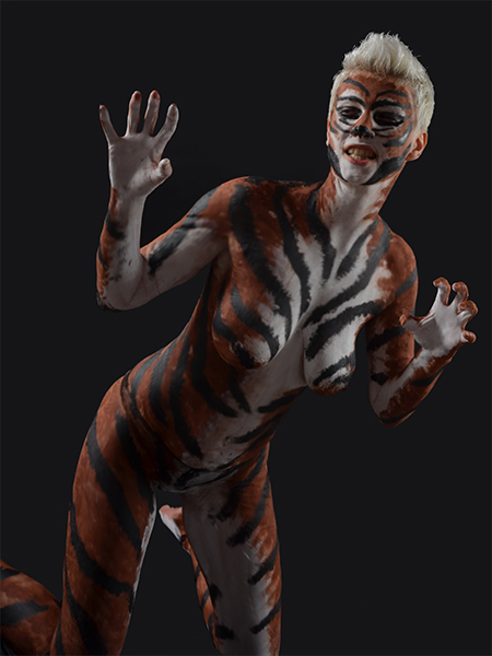 Fertiges Tiger-Bodypainting in ausdrucksstarker Pose vor dunklem Hintergrund